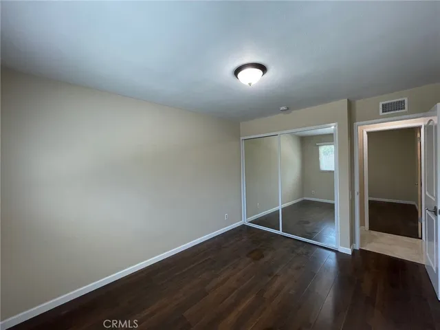 an empty room with wooden floor and closet