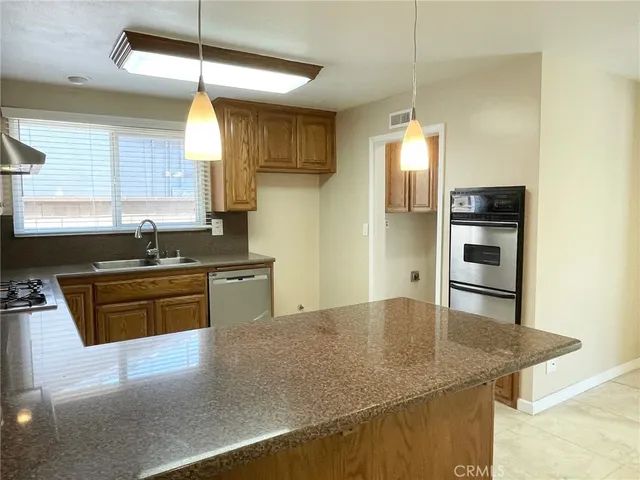 a kitchen with stainless steel appliances granite countertop a sink a stove and a refrigerator