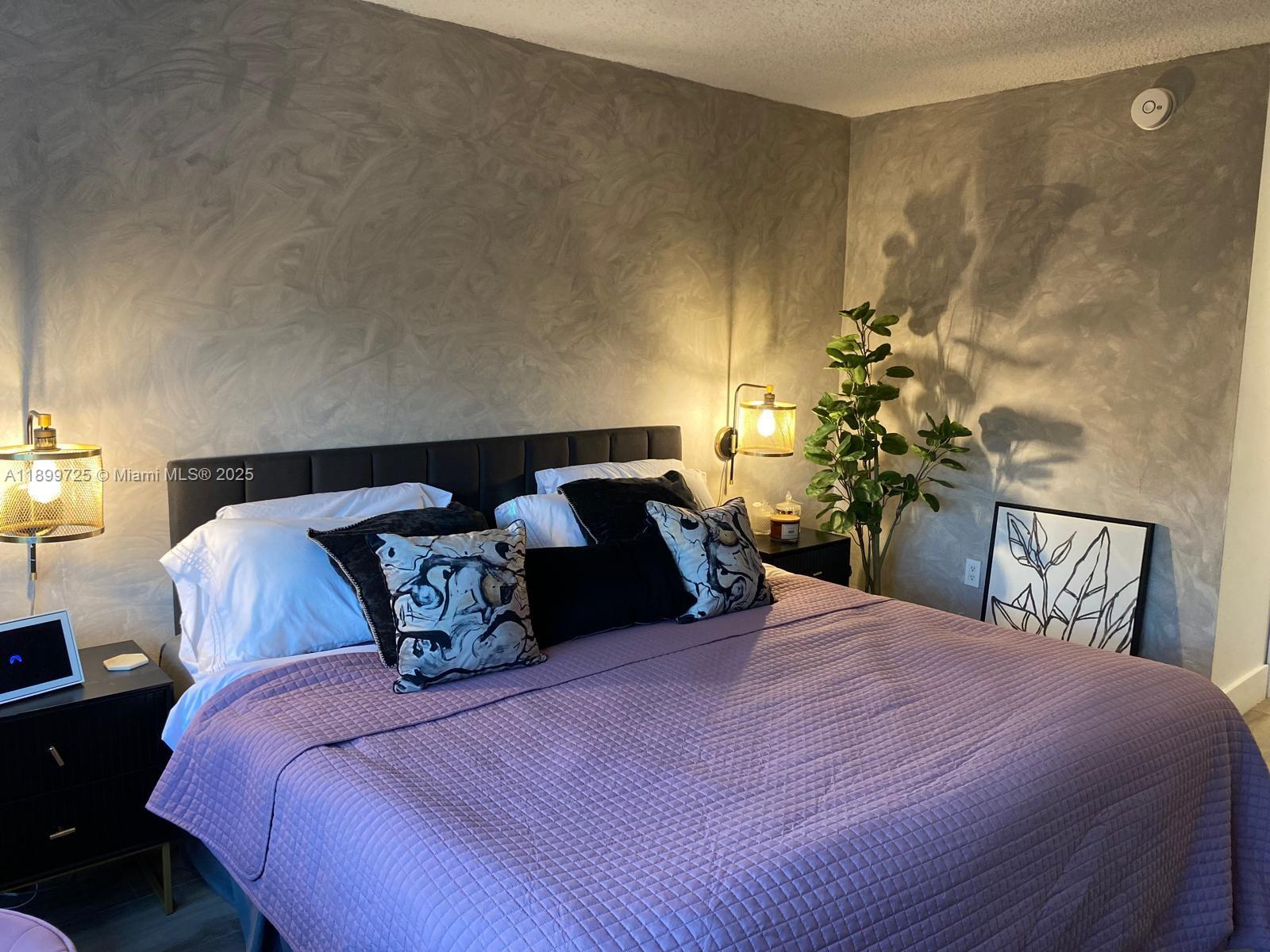 550 Ocean Drive, Unit 2D Key Biscayne, FL 33149 - Photo 22 of 35 a bedroom with a bed and a potted plant