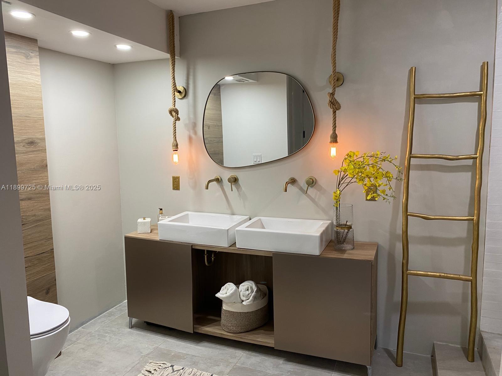 550 Ocean Drive, Unit 2D Key Biscayne, FL 33149 - Photo 26 of 35 a bathroom with a sink a toilet and a mirror