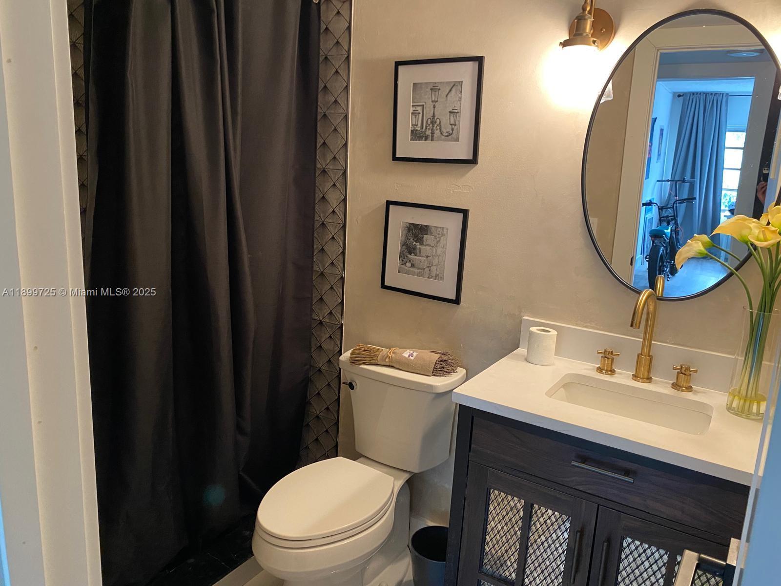 550 Ocean Drive, Unit 2D Key Biscayne, FL 33149 - Photo 29 of 35 a bathroom with a toilet a sink and mirror