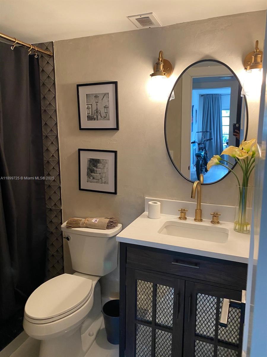 550 Ocean Drive, Unit 2D Key Biscayne, FL 33149 - Photo 30 of 35 a bathroom with a toilet a sink and mirror