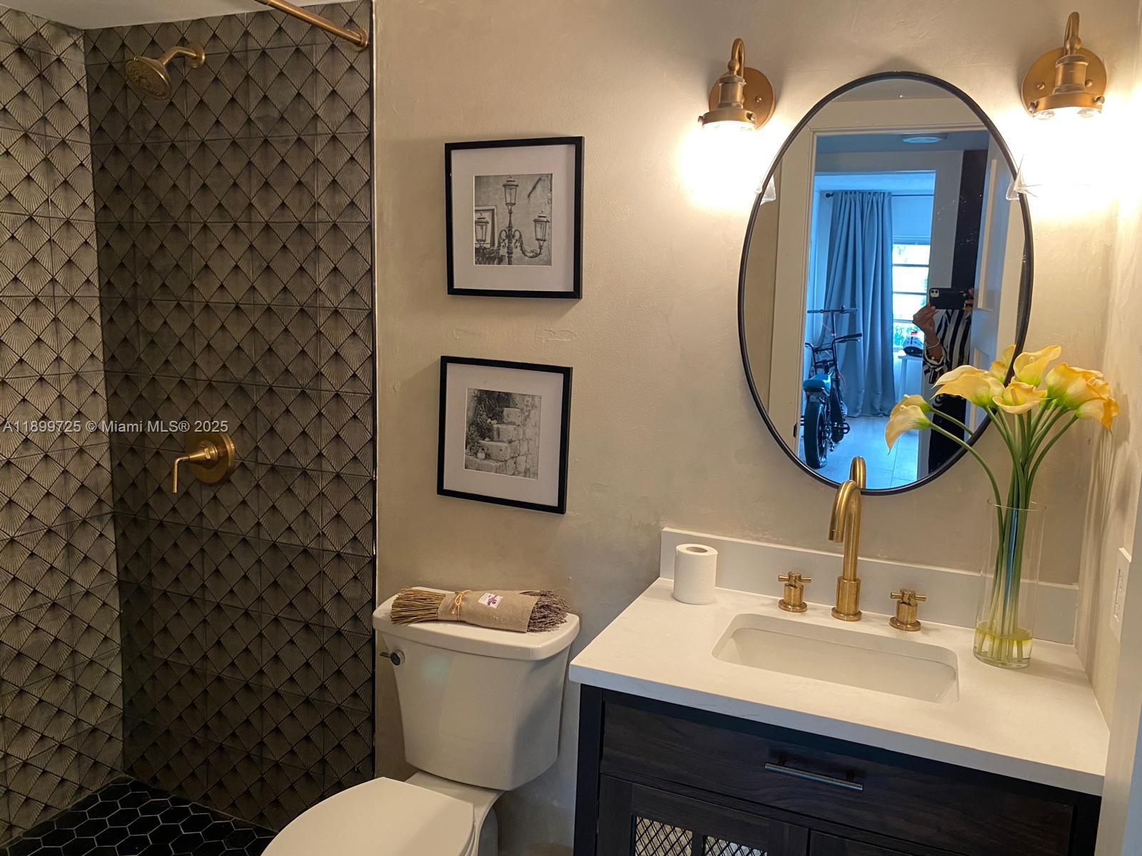 550 Ocean Drive, Unit 2D Key Biscayne, FL 33149 - Photo 31 of 35 a bathroom with a toilet sink and mirror