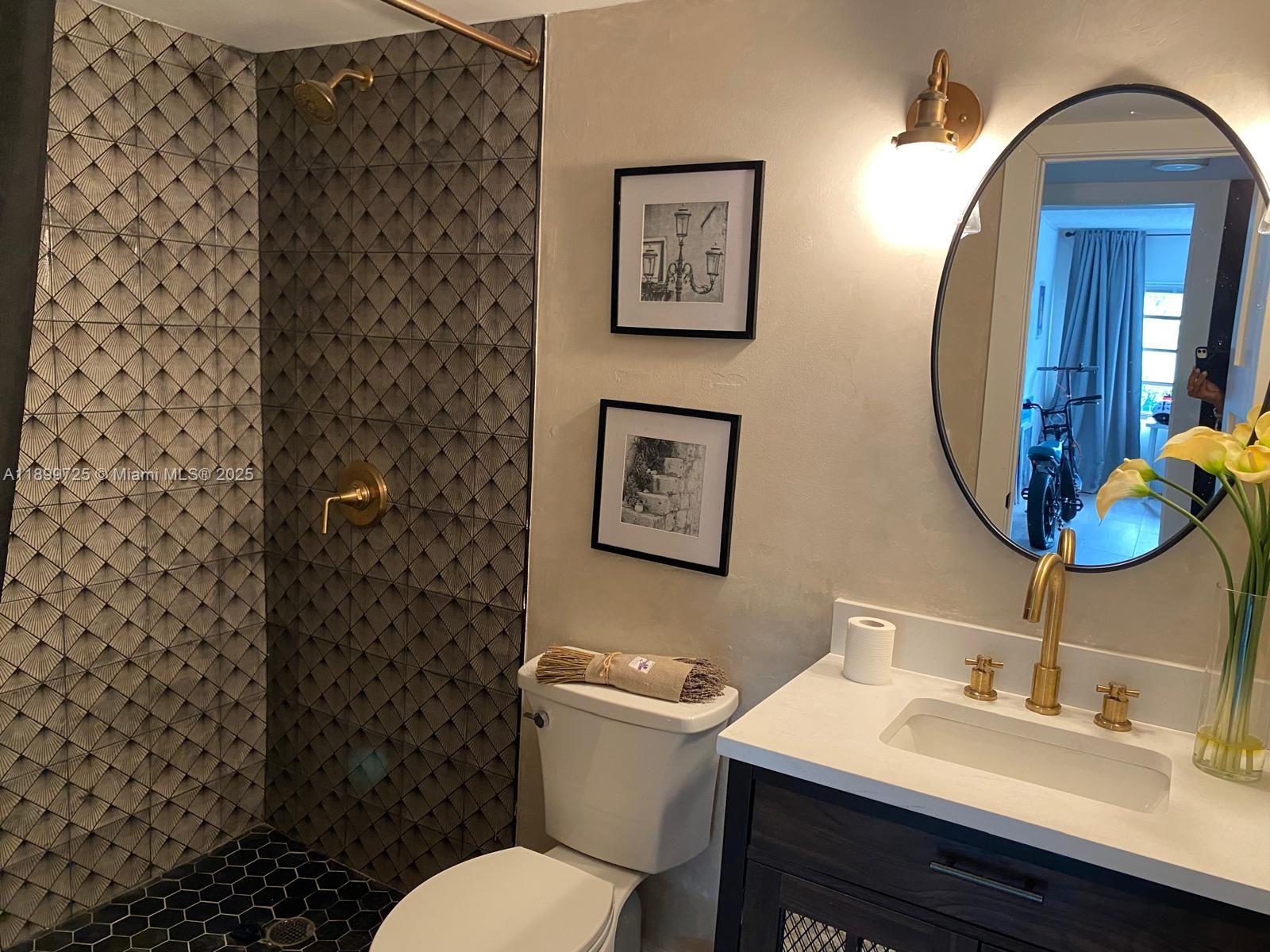 550 Ocean Drive, Unit 2D Key Biscayne, FL 33149 - Photo 32 of 35 a bathroom with a sink mirror vanity and toilet