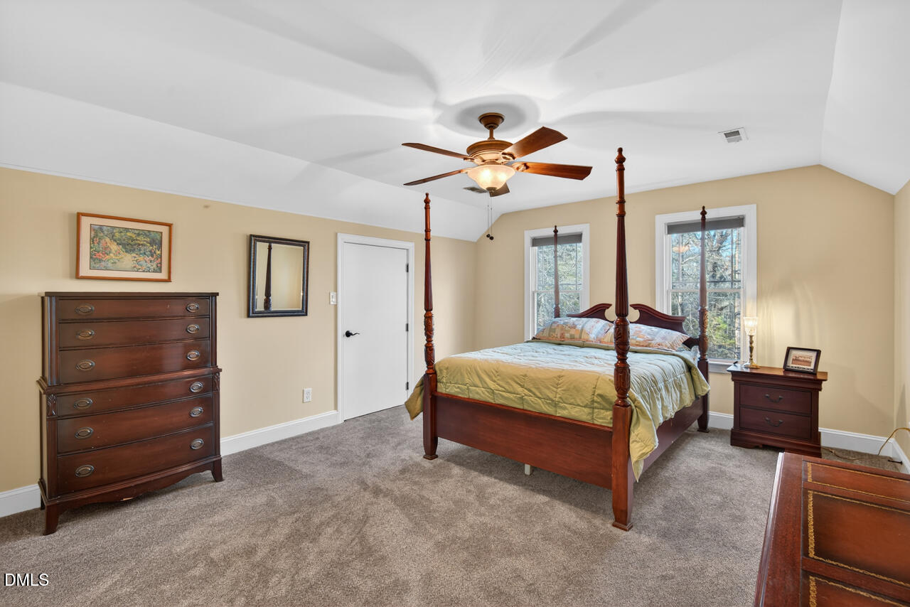 10775 Buffalo Creek Road Rougemont, NC 27572 - Photo 45 of 65 a bedroom with a bed and a chandelier