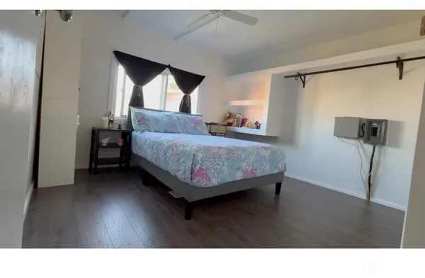 a living room with a bed furniture and a wooden floor