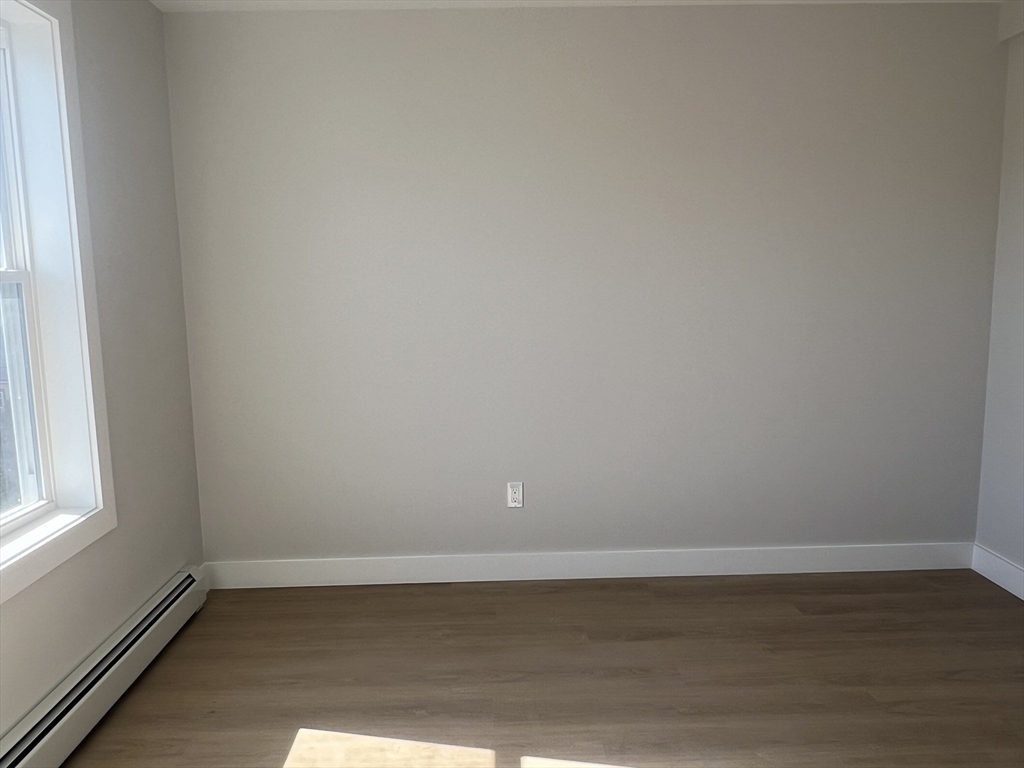 151 Shepard Street, Unit 14 Lynn, MA 01902 - Photo 14 of 22 a view of an empty room with wooden floor and a window