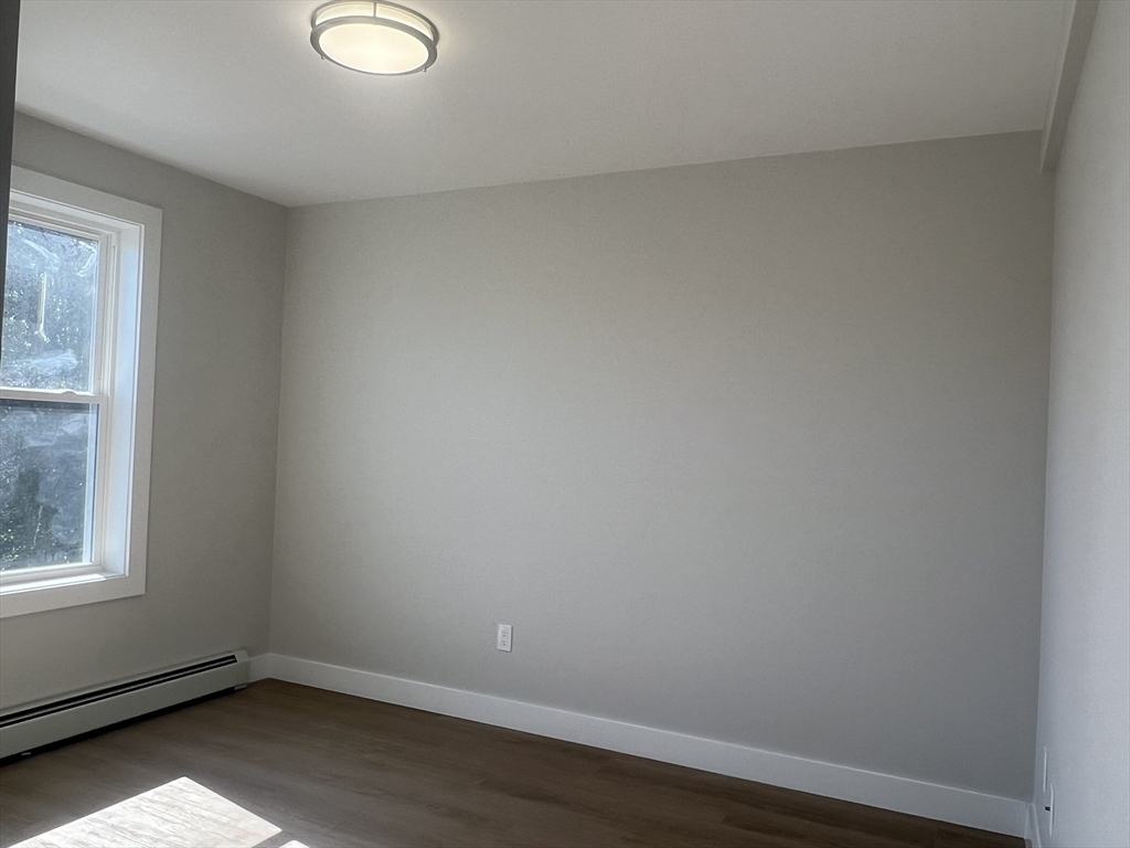 151 Shepard Street, Unit 14 Lynn, MA 01902 - Photo 17 of 22 wooden floor in an empty room with a window