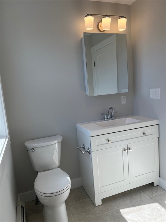 151 Shepard Street, Unit 14 Lynn, MA 01902 - Photo 9 of 22 a bathroom with a toilet sink and mirror