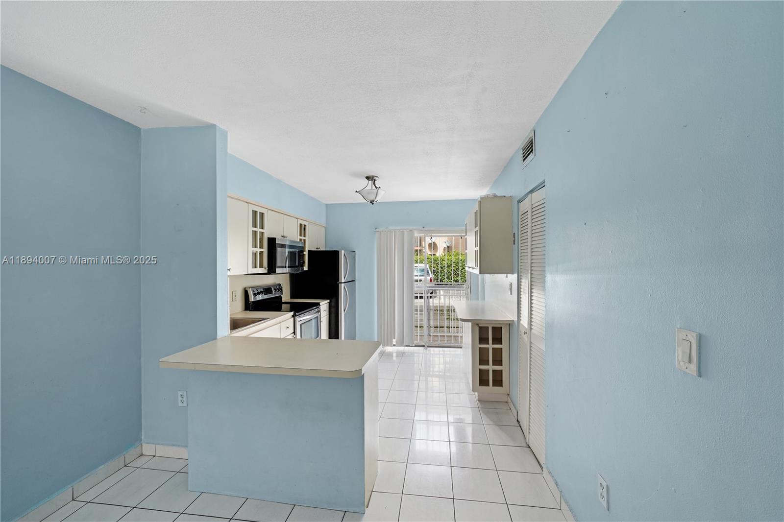 5490 West 21st Court, Unit 112 Hialeah, FL 33016 - Photo 19 of 43 a kitchen with granite countertop a refrigerator and cabinets