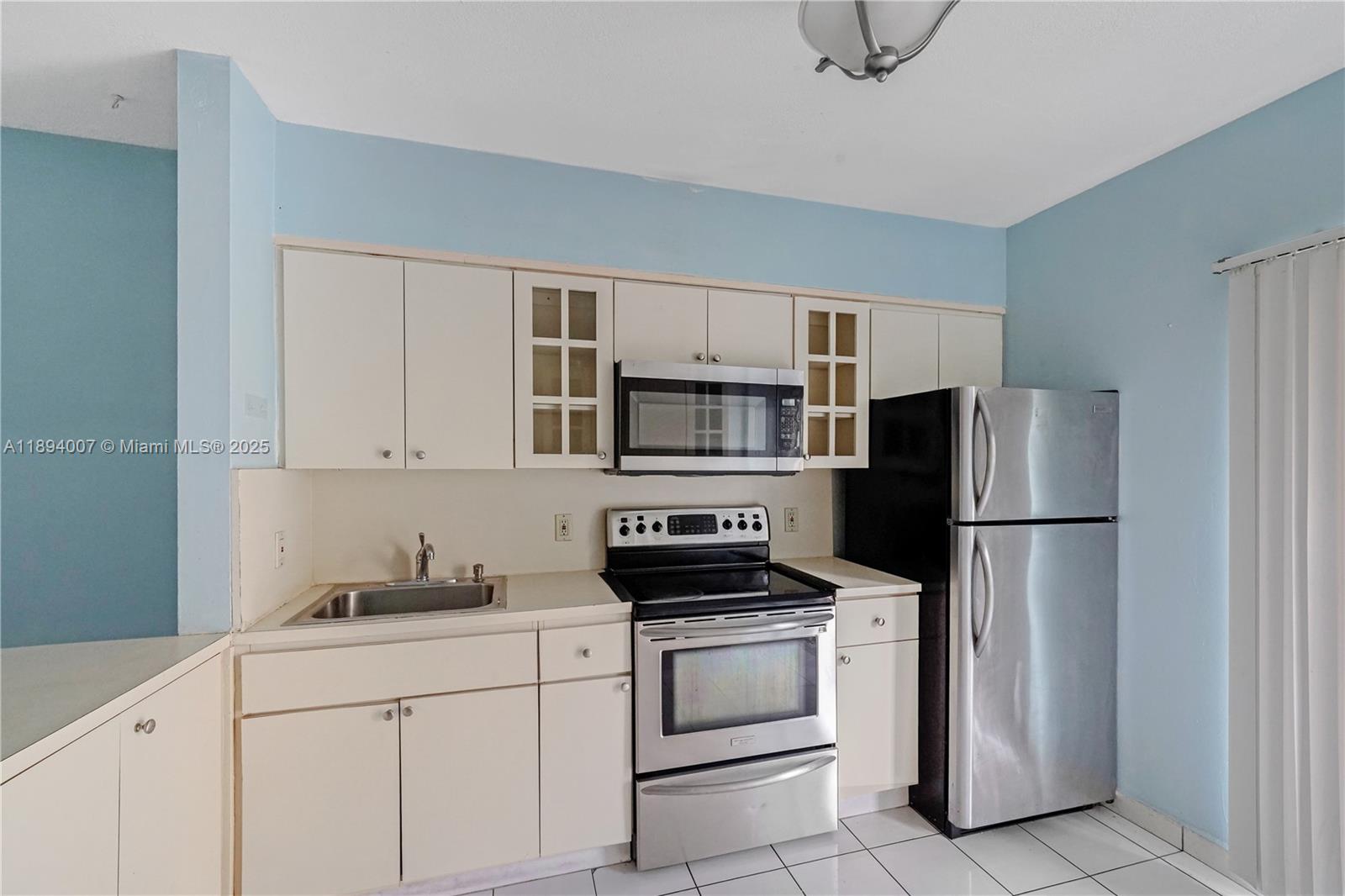 5490 West 21st Court, Unit 112 Hialeah, FL 33016 - Photo 2 of 43 a kitchen with stainless steel appliances a refrigerator stove and microwave