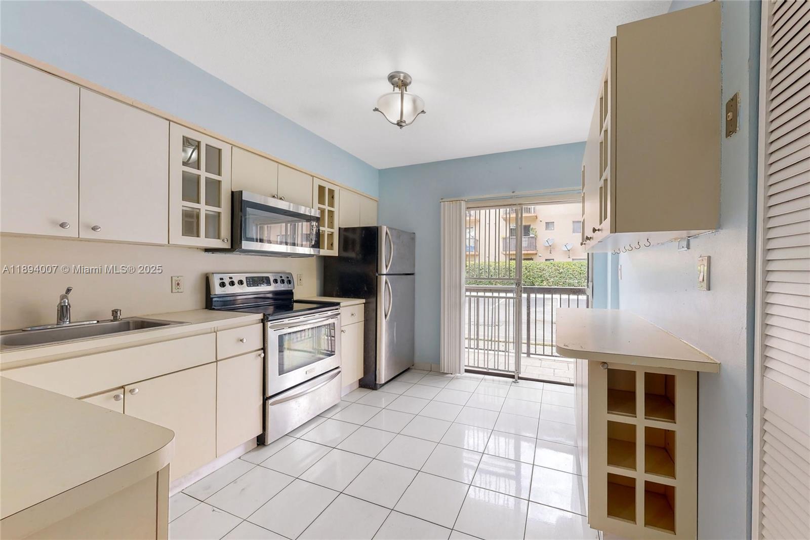 5490 West 21st Court, Unit 112 Hialeah, FL 33016 - Photo 21 of 43 a kitchen with stainless steel appliances granite countertop a stove a sink and a refrigerator