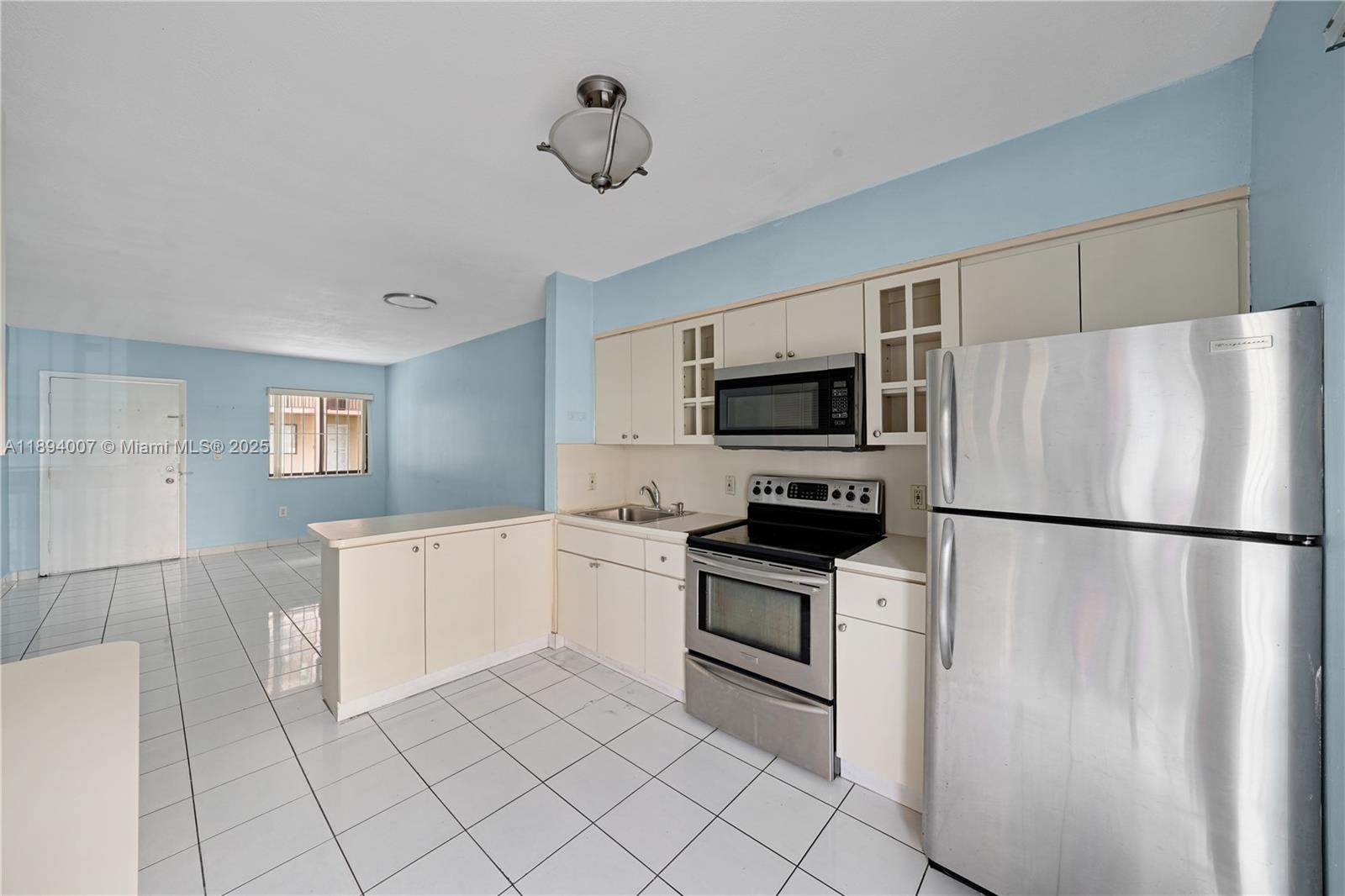 5490 West 21st Court, Unit 112 Hialeah, FL 33016 - Photo 25 of 43 a white refrigerator freezer and a stove sitting inside of a kitchen
