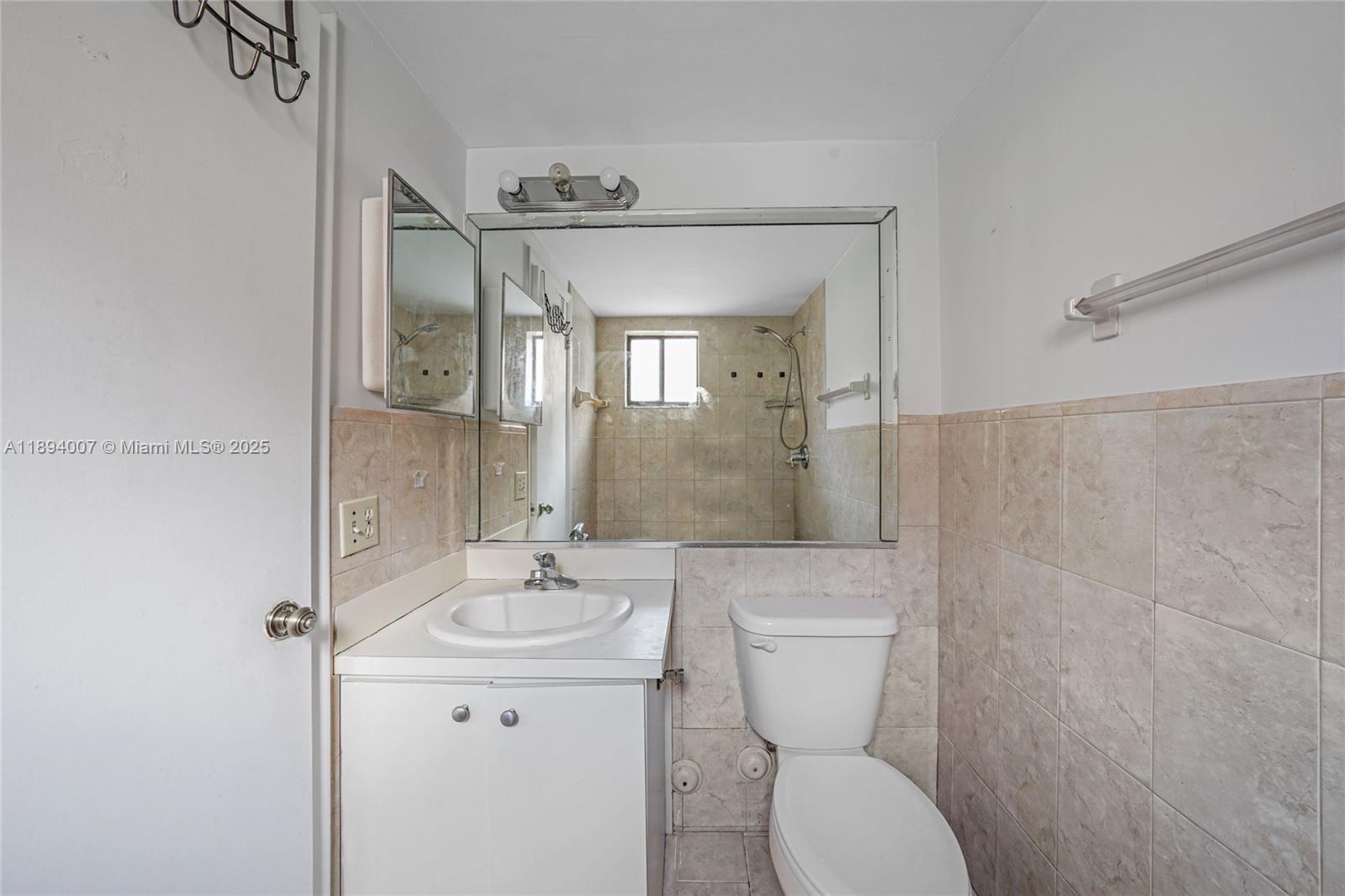 5490 West 21st Court, Unit 112 Hialeah, FL 33016 - Photo 10 of 43 a bathroom with a toilet sink and mirror