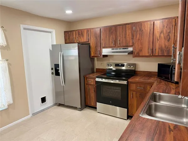 a kitchen with granite countertop a refrigerator stove and microwave