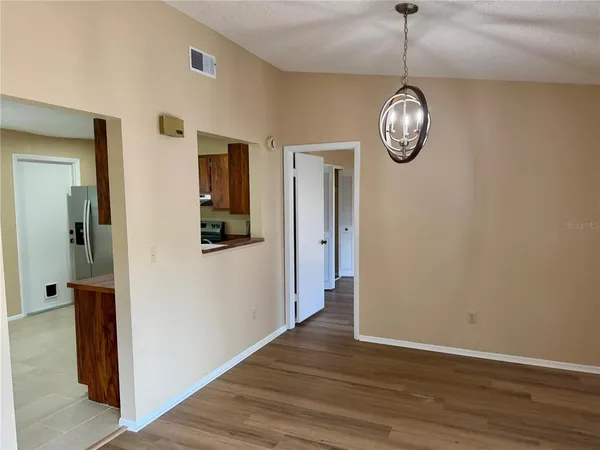 a view of a hallway with wooden floor and a clock