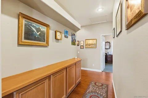 a hallway with painting on the wall and a window