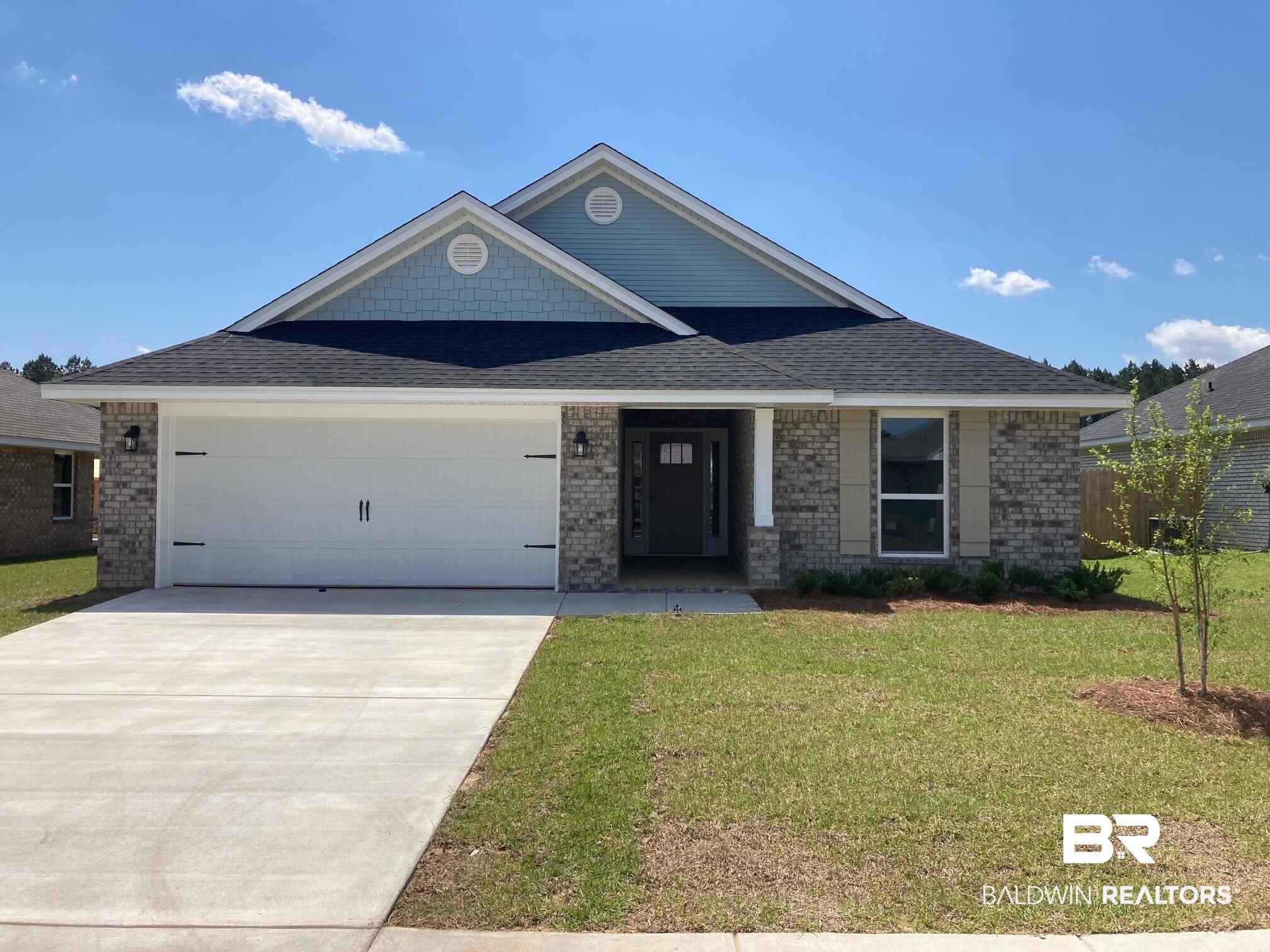 658 Revere Street Foley, AL 36535 - Photo 1 of 14 View of front of home with a front yard, a shingled roof, an attached garage, brick siding, and driveway