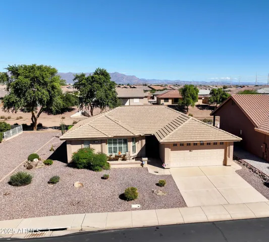 an aerial view of a house with yard and seating space