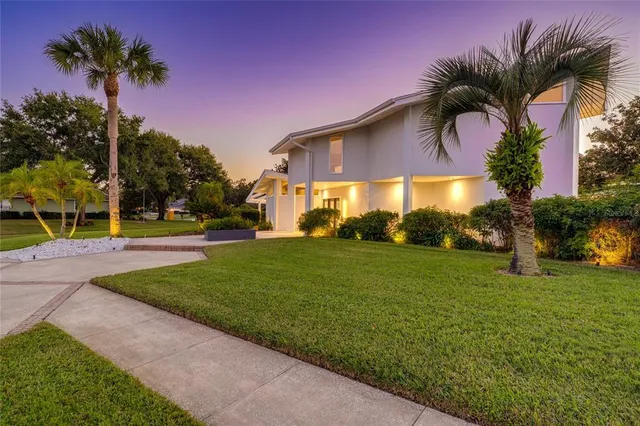 a front view of a house with a yard and potted plants