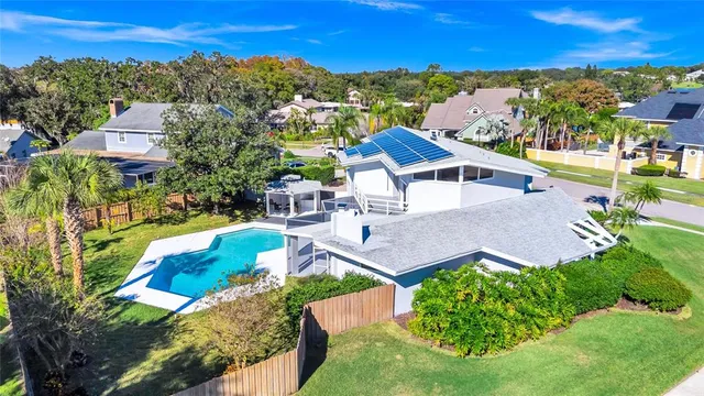 a view of a house with pool yard and a large tree