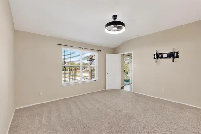 a view of an empty room with closet and a window
