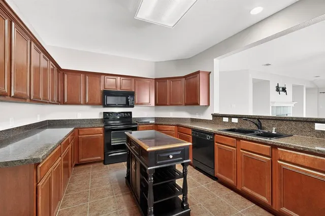 a kitchen with stainless steel appliances granite countertop wooden cabinets sink stove and granite counter top