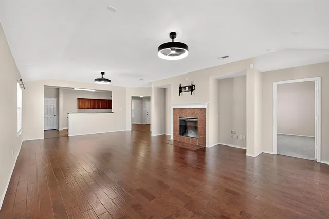 a view of a livingroom with wooden floor and a fireplace