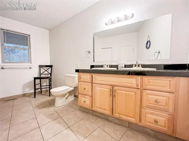 a view of house with patio outdoor seating and covered with trees