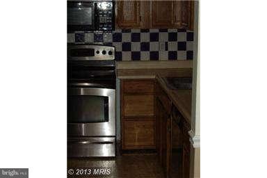 251 Delicious Road Linden, VA 22642 - Photo 13 of 27 a kitchen with a refrigerator and cabinets