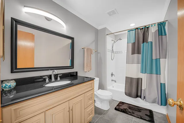 a bathroom with a toilet sink a mirror a vanity and shower