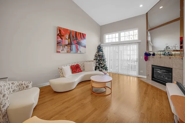 a living room with furniture a fireplace and a large window