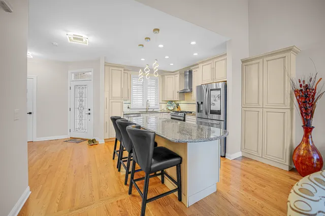 a kitchen with stainless steel appliances granite countertop a refrigerator and a stove top oven