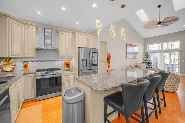 a kitchen with stainless steel appliances granite countertop a stove refrigerator a sink dishwasher with a dining table and chairs