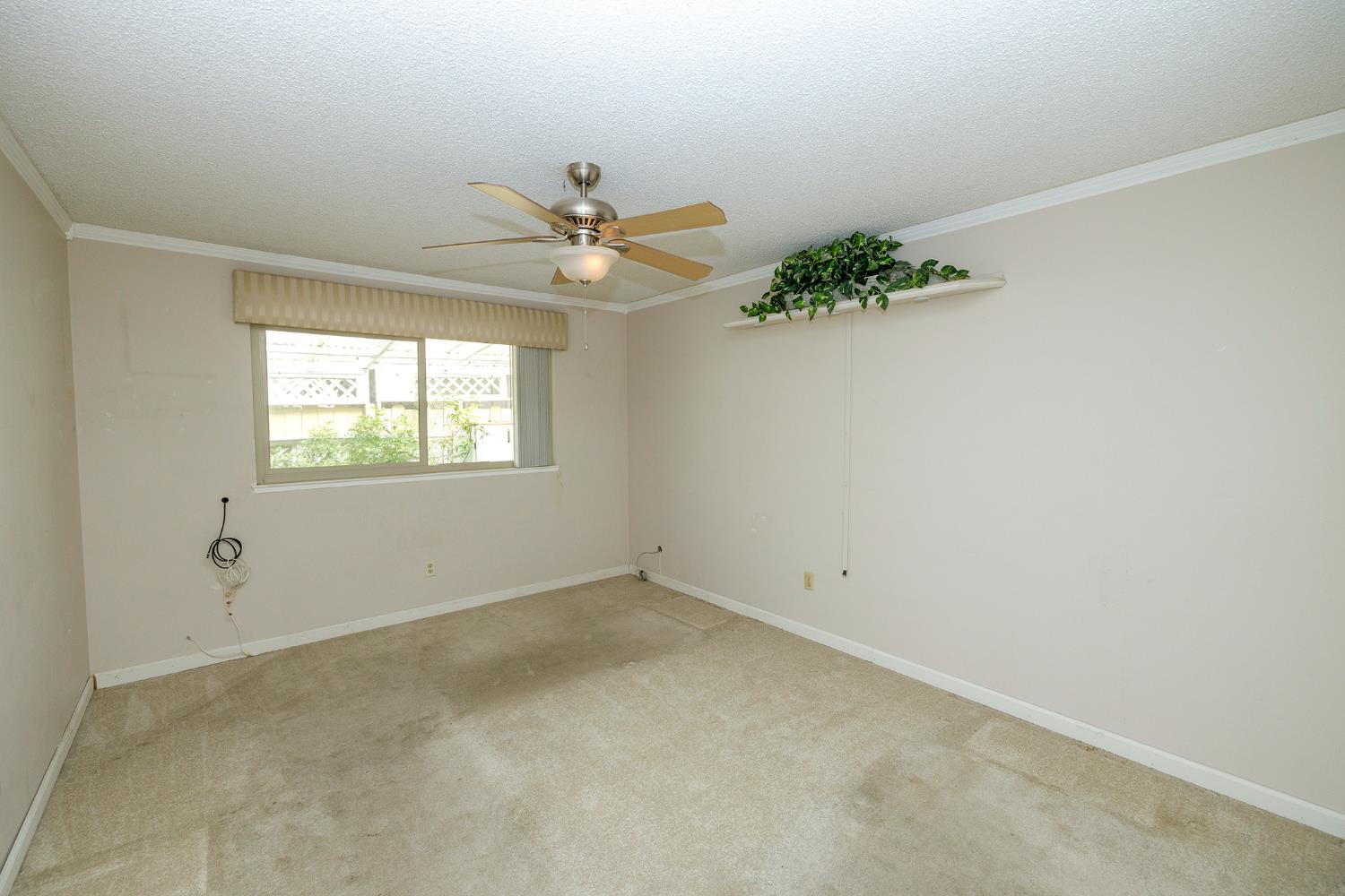 617 West Granger Avenue, Unit 48 Modesto, CA 95350 - Photo 15 of 27 an empty room with a window and a chandelier fan