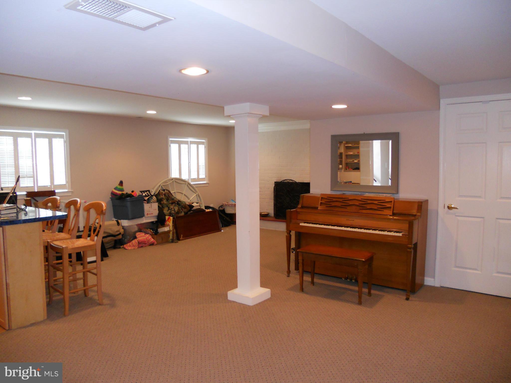 19129 Willow Grove Road Olney, MD 20832 - Photo 13 of 18 a living room with furniture a piano and a flat screen tv