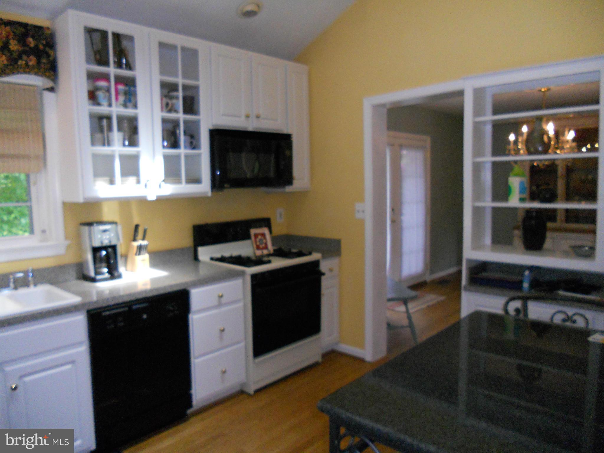 19129 Willow Grove Road Olney, MD 20832 - Photo 3 of 18 a kitchen with stainless steel appliances granite countertop a stove a sink and a microwave