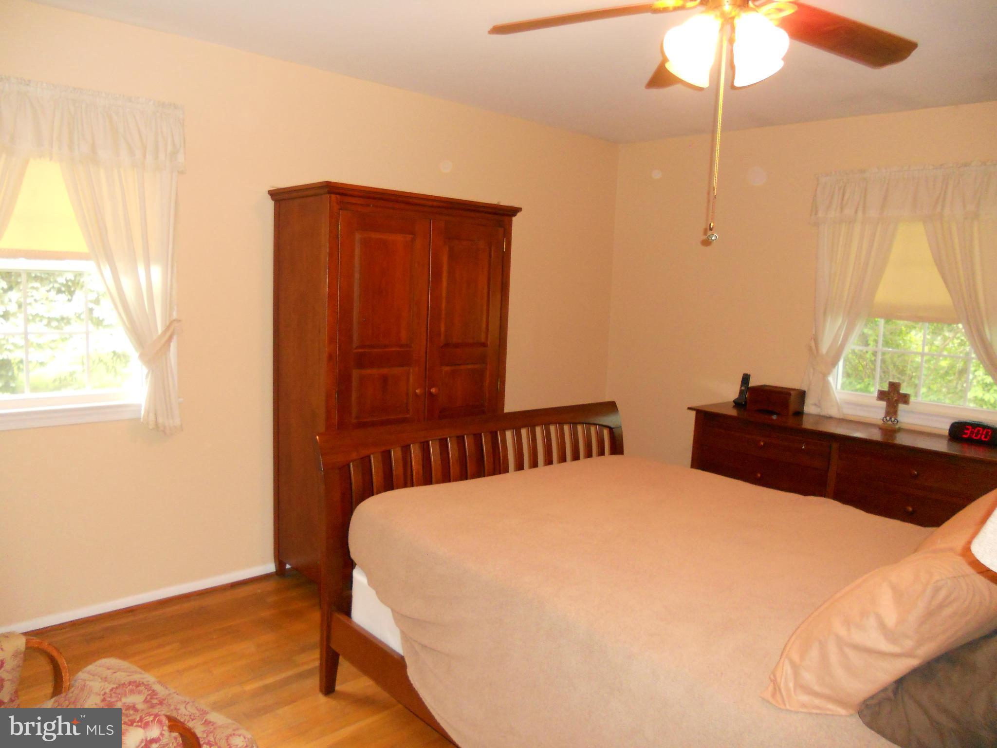19129 Willow Grove Road Olney, MD 20832 - Photo 8 of 18 a bedroom with a bed and a chandelier fan