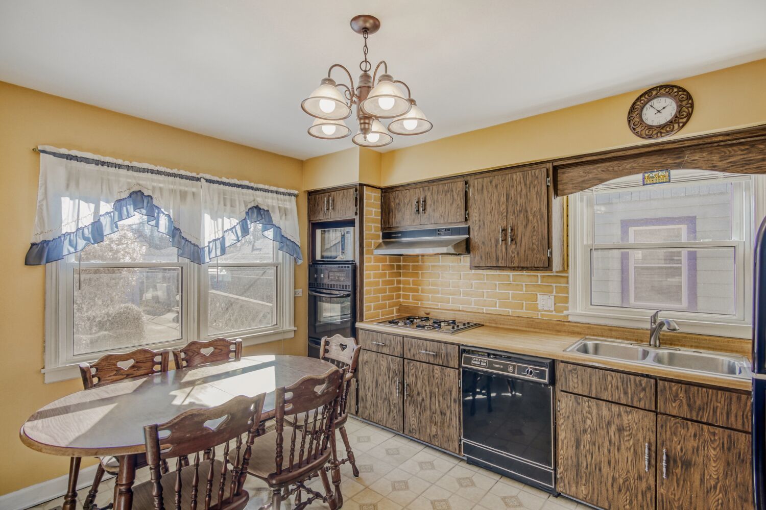 3659 Madison Street Lansing, IL 60438 - Photo 9 of 28 a kitchen with a table chairs stove and cabinets