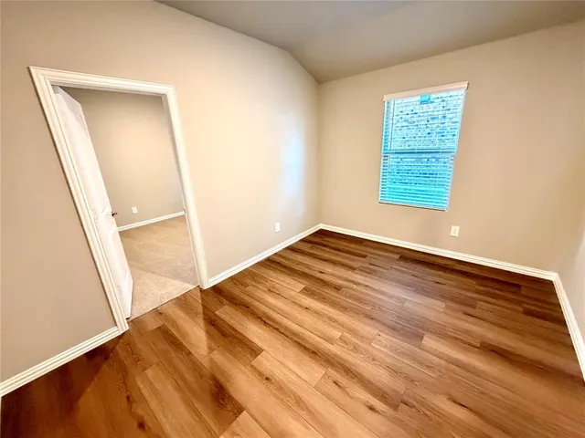 an empty room with wooden floor and a window