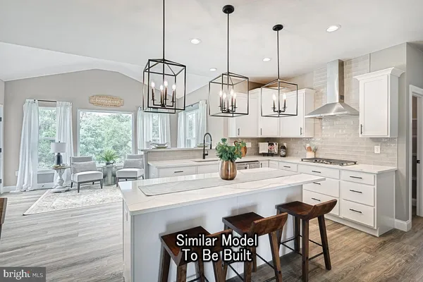 a kitchen with stainless steel appliances granite countertop a sink a stove a refrigerator dining table and chairs