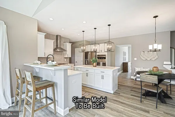 a kitchen with a dining table chairs and white cabinets