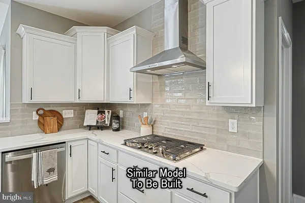 a kitchen with stainless steel appliances granite countertop a stove a sink and a white cabinets