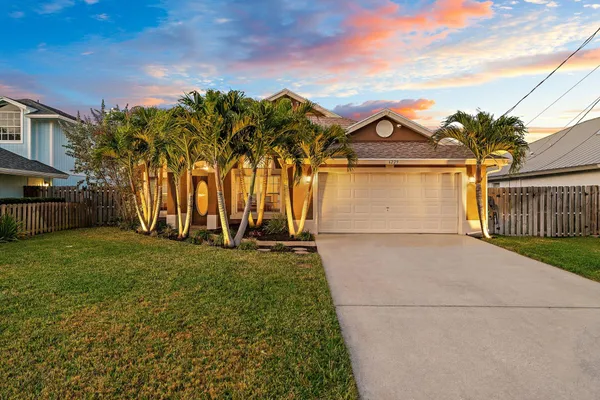 a front view of a house with a garden and yard