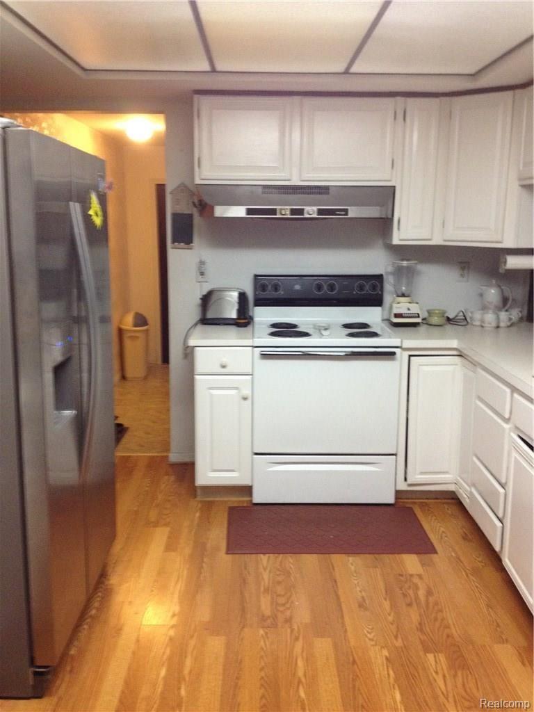 Kitchen view from dining table toward back hall to 2nd bathroom and laundry/mud room