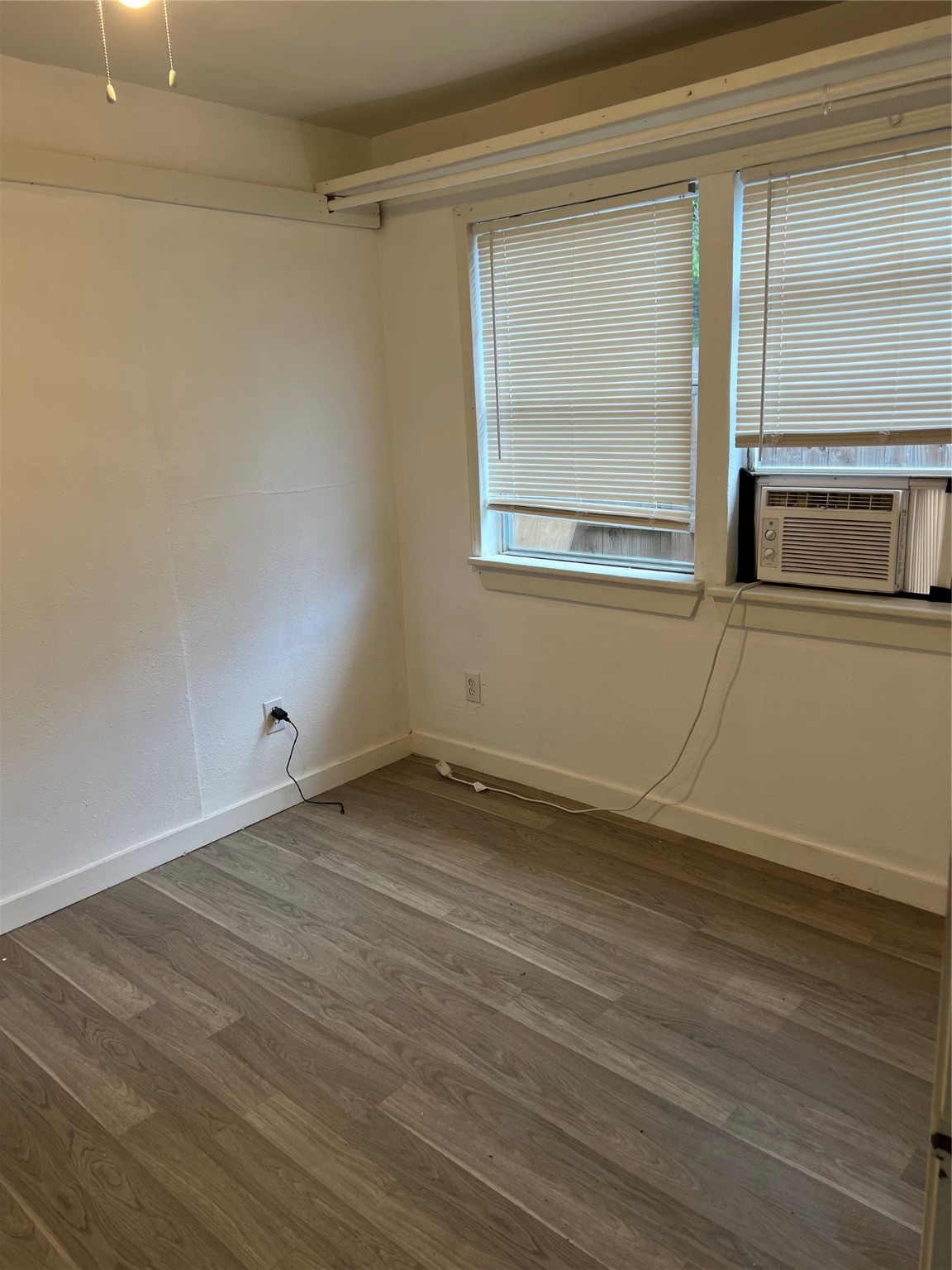 7909 Brutus Street, Unit 3 Houston, TX 77012 - Photo 7 of 9 a view of an empty room with wooden floor and a window