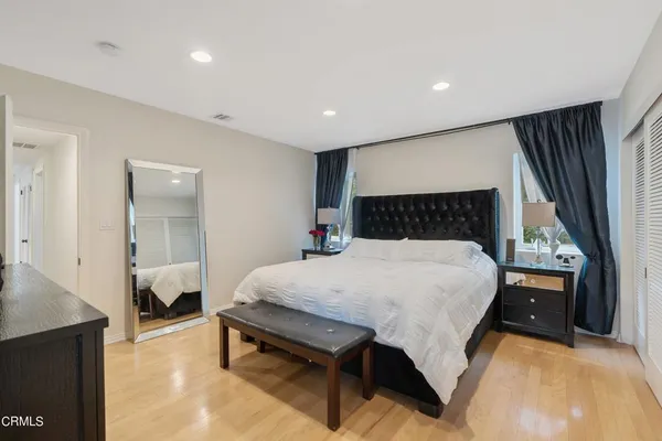 a bed sitting in a spacious bedroom next to a window