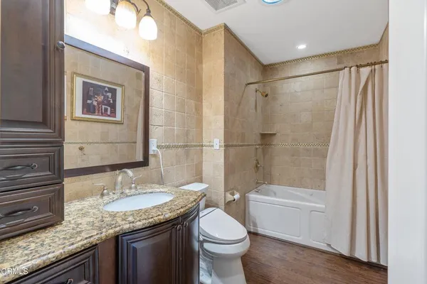 a bathroom with a granite countertop sink toilet and shower