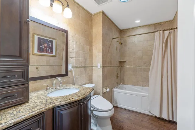 a bathroom with a granite countertop sink toilet and shower