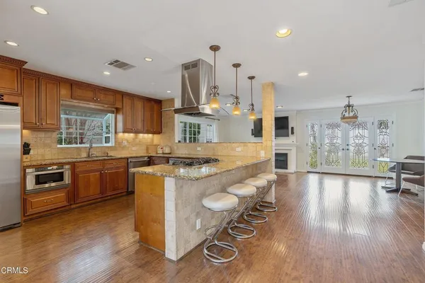 a kitchen with stainless steel appliances granite countertop a stove and a wooden floors